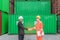 Asian manager and man worker shaking hands in cargo container area