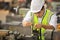 Asian mechanic worker in safety hard hat and reflective cloth is working with lathe machine in the factory