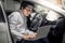 Asian mechanical engineer working with laptop in the car