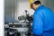 Asian mechanical worker male working on milling machine in factory. Technicians wear protective glasses and helmet when operating