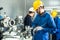 Asian mechanical workers working on milling machine. The technicians wearing protective glasses and helmet when operating the mach