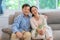 Asian middle-aged couples sit and relax on the sofa in the living room