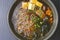 Asian Miso ramen noodles with egg, tofu and meat served in a bowl on dark rustic wooden background.