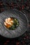 Asian miso soup ,soy sauce, greens and shrimps prawn. On a black stone background