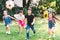 Asian and mixed race happy young kids running playing football together in garden. Multi-ethnic children group, outdoor exercising