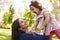 Asian mixed race mum and young daughter playing in park