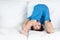 Asian, mixed race toddler boy attempting a hand stand and is upside down.