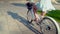 Asian model in a blue dress rides a white bicycle in a green park