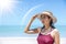 Asian model wear red swimsuit and straw hat stand on beach look view on hot day, Sun and UV rays.