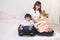 Asian mom and baby girl with suitcase baggage and clothes ready