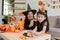 Asian mom and cute daughter celebrate Halloween and balloon pumpkin together at home. Halloween activity concept