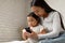 Asian Mommy And Little Baby Daughter Using Smartphone At Home