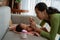 Asian mother cleaning between finger folds of little girl