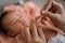 Asian mother cleaning between finger folds of little girl