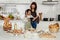 Asian mother and cute daughter, happy young mother teach cook together with small daughter doing bakery and learning computer and