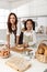 Asian mother and cute daughter, happy young mother teach cook together with small daughter doing bakery and learning to make cake