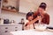 Asian Mother And Daughter Making Messy Cupcakes In Kitchen At Home Together
