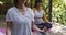 Asian mother and daughter meditating together in garden