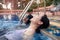 Asian mother and daughter relaxing in the swimming pool with happiness and emotions