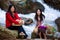 Asian mother and daughter sitting by river