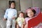 Asian mother with daughter and son read fairy tale. Female with her little children enjoying book indoors