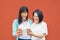 Asian mother and daughter using mobile smartphones outdoor - Happy Chinese family having fun with new trends technology apps