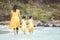 Asian mother and daughter walking and playing on beach