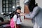 asian mother fasten her daughter helmet before going to school