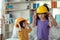 Asian mother helping daughter wearing engineer helmet, education and occupation concept