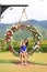 Asian mother and her daughter sitting on beautiful basket swing with the colorful roses flower in the nature garden hanging on