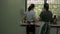 Asian mother and her daughter wearing apron preparing and cleaning utensils on the dish cabinet in the kitchen.