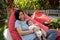 Asian mother holding baby while resting on lazy bag