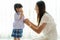 Asian mother preparing kindergarten student uniform to her little daughter for school getting ready for school in living room at