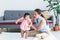 Asian mother smiling and happy as she supports her 7-month-old daughter learning to stand