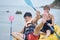 Asian mother and son playing kayaking on the sea during vacation when kid losing balance