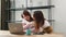 Asian mother and teenage daughter looking at laptop computer at home office