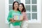 Asian mother and teenage girl holding gift box and smile,