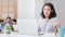 Asian mother work at home with family, father, daughter, and son sit together on sofa couch. New normal lifestyle