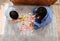 Asian mother work home together with son. Mom and kid play color wooden block. Child creating building toy.