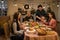 an asian multi-generational family joyfully gathers around a festive dinner table, celebrating christmas or thanksgiving, sharing