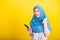 Asian Muslim Arab woman Islam wear hijab funny smile she raise hand glad winning with smart mobile phone