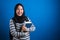 Asian muslim college student girl wearing hijab smiling friendly holding big book