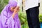 Asian Muslim couple, man and woman, praying at home