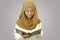 Asian muslim girl wearing hijab holding and reciting Quran, holy book of islam religion