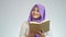 Asian muslim lady smiling while reading book, thinking and pointing finger up, finding great idea