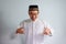 Asian Muslim man wearing glasses and white cloth smiling  pose for ramadhan