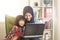Asian muslim mom and little baby girl daughter learning online or watching videos on laptop, happiness between mother and kid,
