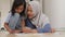 Asian muslim mother drawing with her daughter, single mom teaching baby girl, learning on the floor, happy family