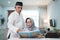 Asian Muslim senior man teaching wife reading Koran or Quran in living room