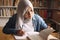 Asian muslim woman studying in library, exam preparation concept. Female college student doing research and making notes in her